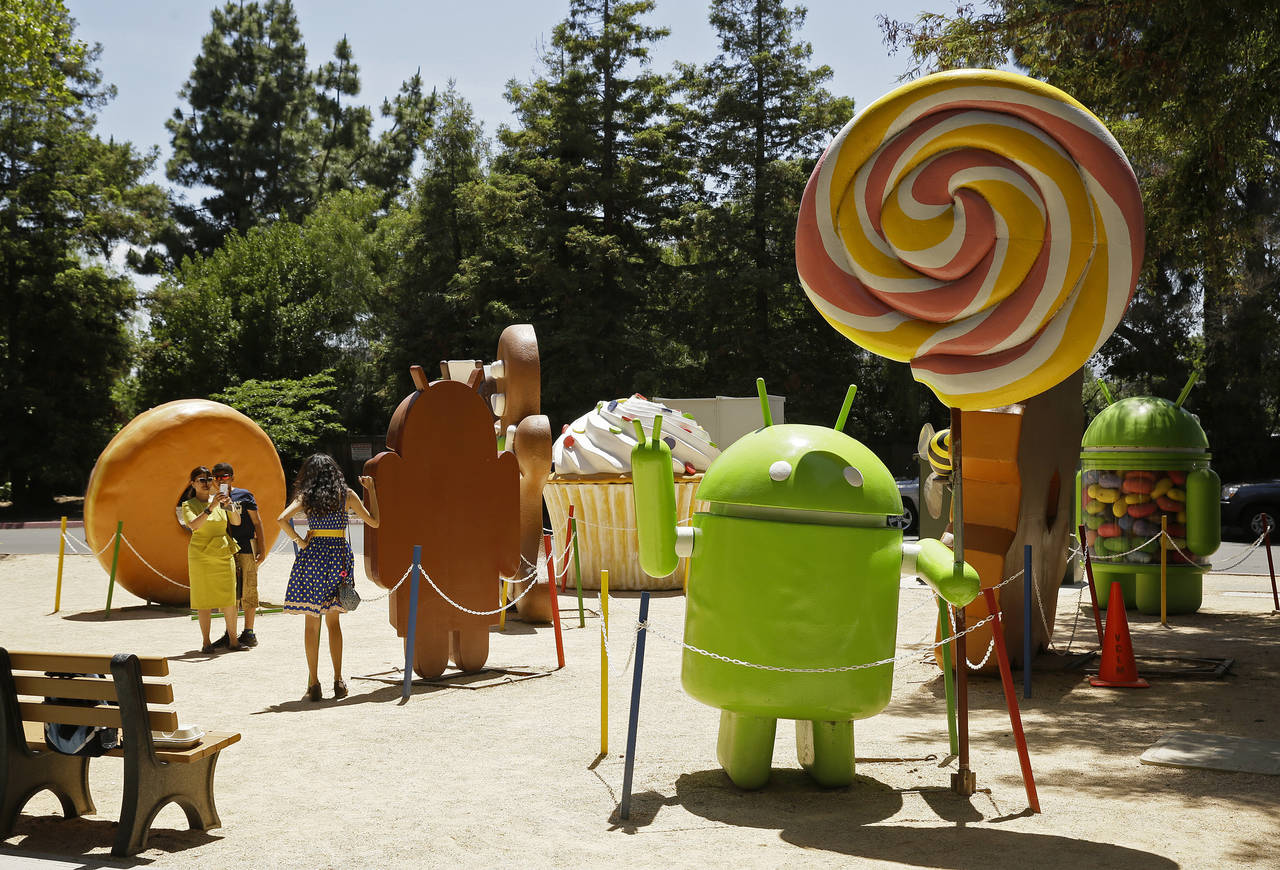 Simple. Un grupo de personas se toman fotografías con las figuras de Android en un jardín de Google. (ARCHIVO)