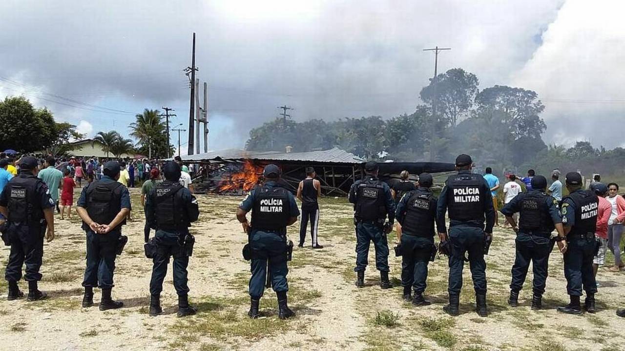 Protesta. Policías prestan guardia mientras brasileños se manifiestan en contra de venezolanos. (EFE)
