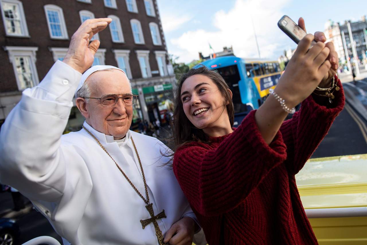 Relevante.Una joven se toma su ‘selfie’ con una figura del Papa
en Dublín. Inicia una crucial visita del pontífice en Irlanda.