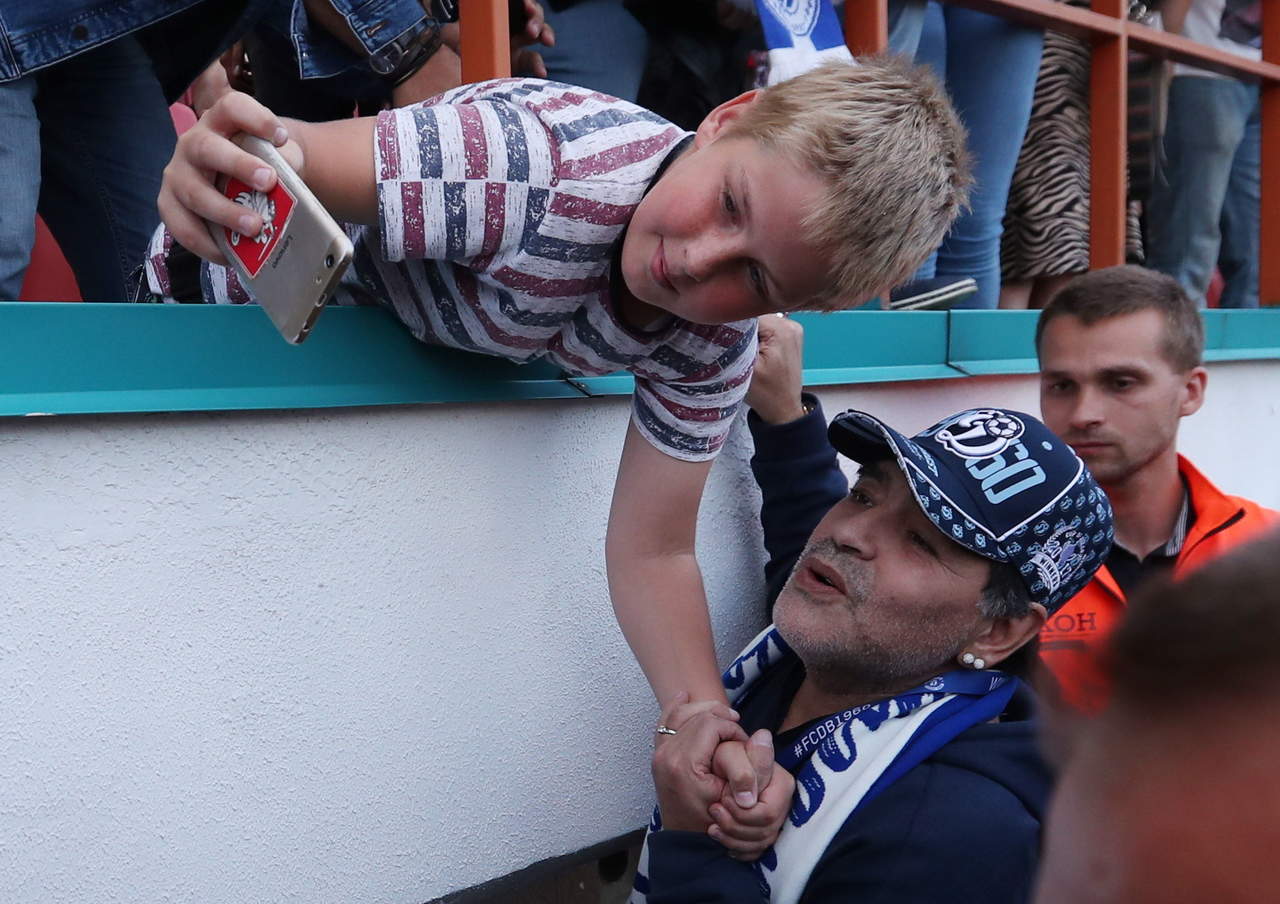 Maradona saluda a un fan antes de un partido en Bielorrusia. (EFE)