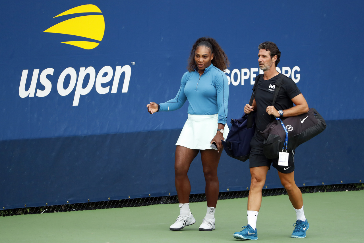 Serena Williams camina por las canchas de prácticas del Abierto de Estados Unidos junto a su entrenador Patrick Mouratoglou.