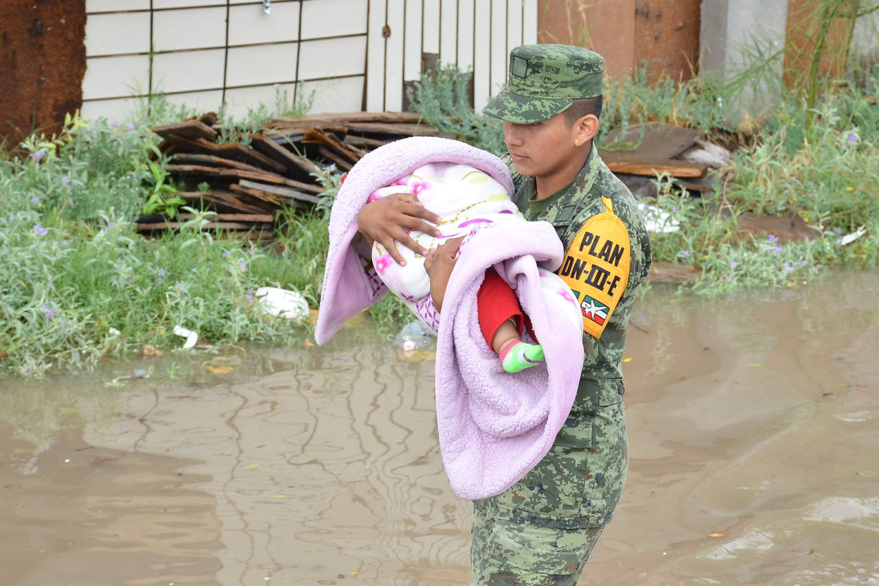 Elementos del ejército ayudaron a las familias a dejar sus hogares en medio de grandes lagunas. (FERNANDO COMPEÁN) 