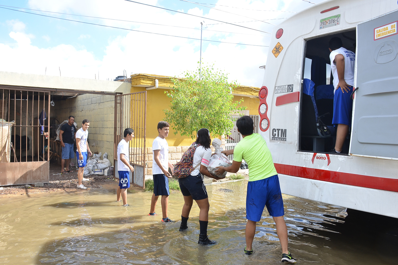 Unidos. Alumnos el ITESM y del Colegio Cervantes se unieron para llevar costales de arena hasta las viviendas más afectadas. (FERNANDO COMPEÁN)