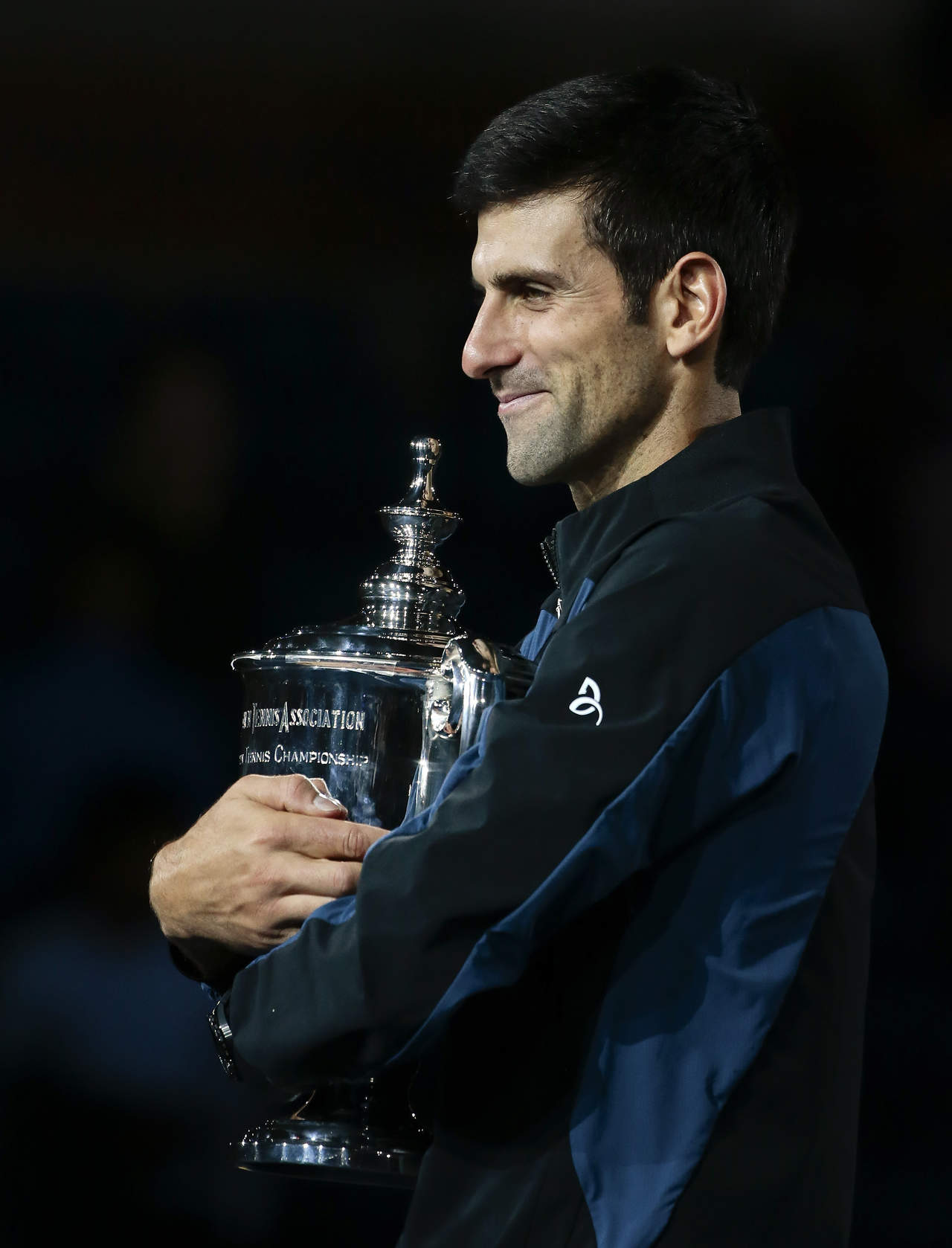 El serbio Novak Djokovic sostiene el trofeo de campeón tras vencer al argentino Juan Martín del Potro en la final de hombres del U.S. Open, en Nueva York.