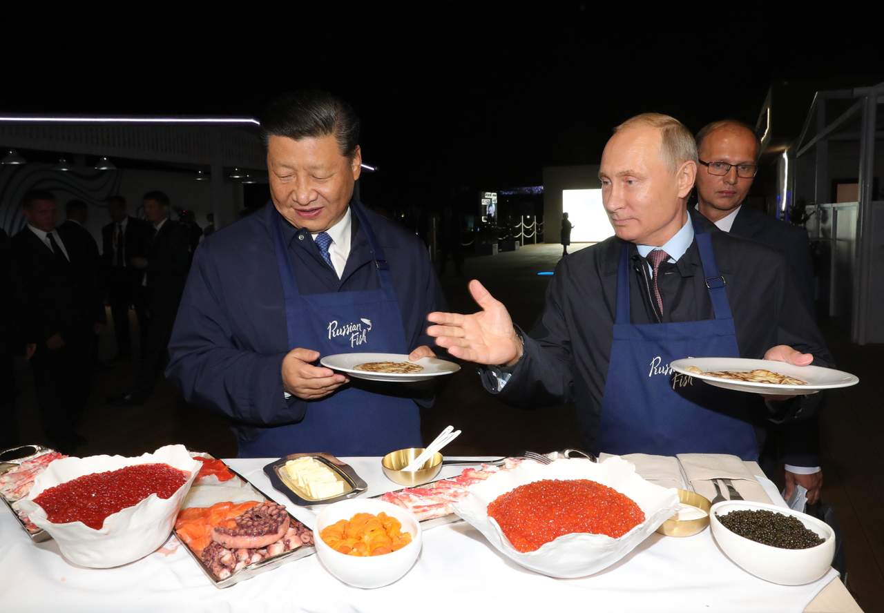 Foro económico. El presidente ruso, Vladimir Putin (d), y su homólogo chino, Xi Jinping, brindan durante su visita a una muestra gastronómica durante el Foro Económico Oriental que se celebra en Vladivostok, Rusia. (EFE)