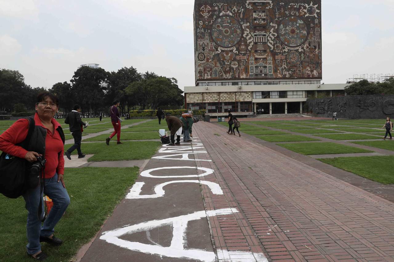 Frente a la Biblioteca Central, cinco de los manifestantes tomaron rodillos para escribir la frase mientras gritaban '¡Fuera Porros de la UNAM!', y '¡Ni perdón, ni olvido. Castigo a los asesinos!'. (EL UNIVERSAL)