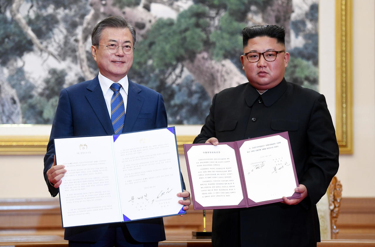 Encuentro. El líder norcoreano, Kim Jong-un (Der.), y el presidente surcoreano, Moon Jae-in (Izq.), muestran los documentos firmados del acuerdo militar entre ambas naciones. (EFE)