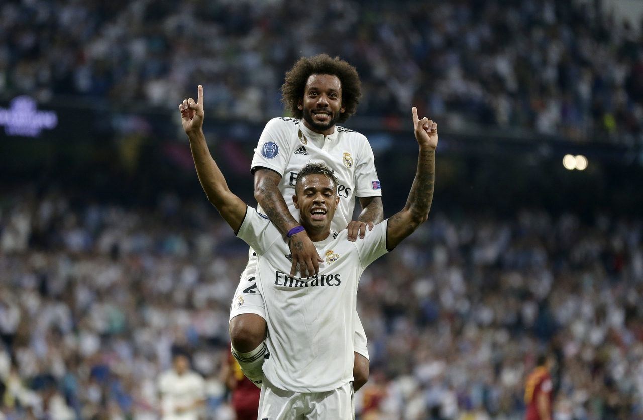 Con Marcelo sobre sus espaldas, el dominicano Mariano Díaz festeja el gol que anotó en la victoria 3-0 de Real Madrid sobre Roma en la Liga de Campeones en el estadio Santiago Bernabéu de Madrid.