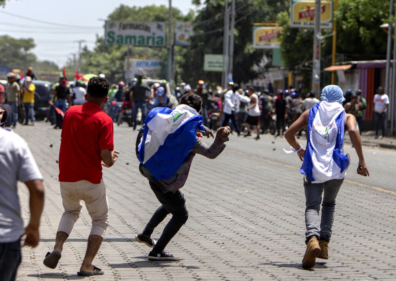 Pelea. Varios jóvenes se enfrentan a las fuerzas de choque del Gobierno durante la marcha 'Somos la Voz de los Presos Políticos'. (EFE y AP)