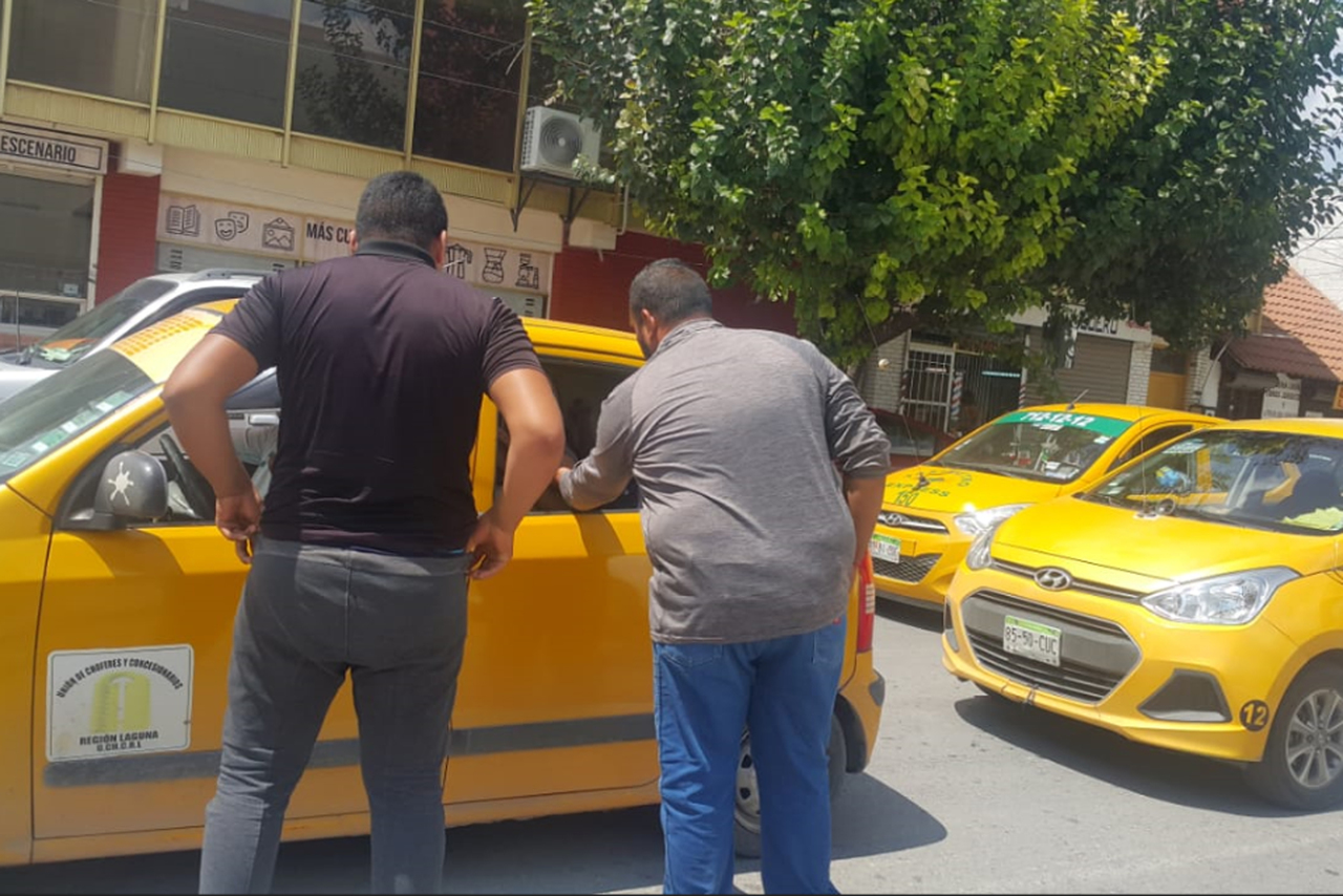 Rodeado. Estos dos choferes de taxis 'cinqueros', que cubren la ruta bulevar Independencia, exigen a chofer del taxi que les entregue lo correspondiente a las personas que transporta. (EL SIGLO DE TORREÓN)