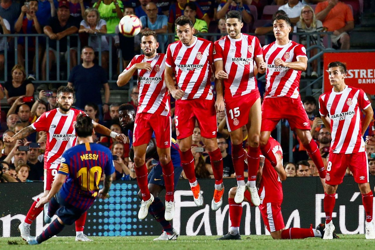 El delantero argentino del Barcelona Leo Messi (2-i) trata de superar la barrera de los jugadores del Girona.