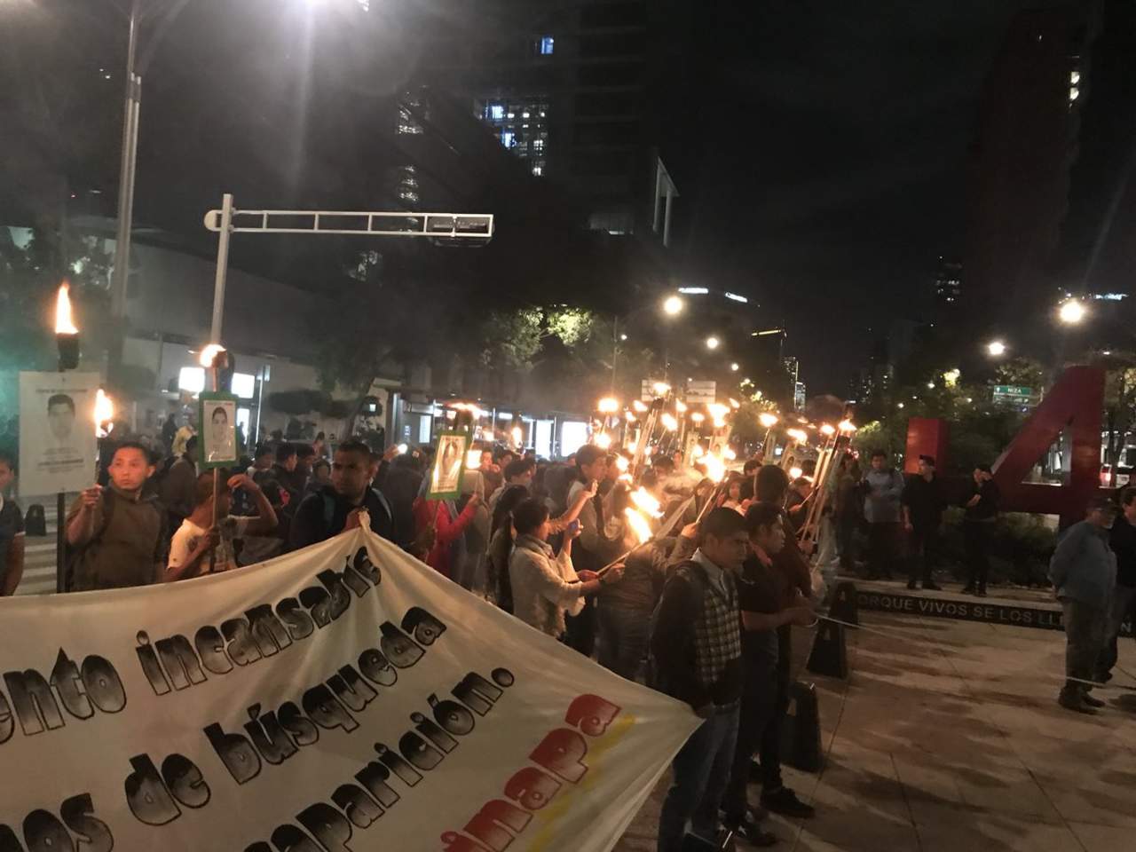 Los manifestantes, quienes lanzaban diversas consignas, portaban antorchas e imágenes de sus familares desparecidos entre el 26 y 27 de septiembre de 2014.  (ESPECIAL)