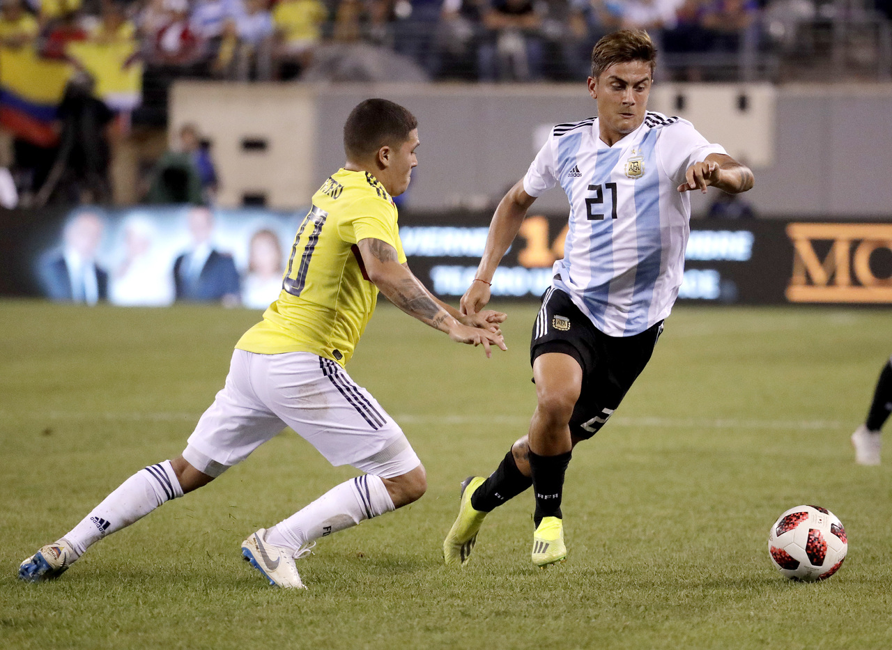El delantero argentino Paulo Dybala (derecha) avanza con el balón frente al volante colombiano Juan Fernando Quintero.
