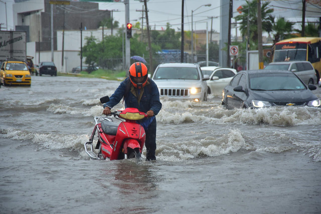 El bulevar Independencia fue de los más afectados por la inundación causada por la lluvia. En la imagen un motociclista bajó de la misma al ya no arrancar.
