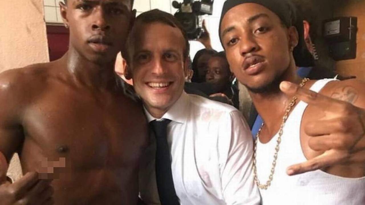 El presidente francés sale retratado en medio de los dos, uno de ellos con el torso desnudo y otro con una camiseta de tirantes de la que colgaba un grueso collar. (ESPECIAL)