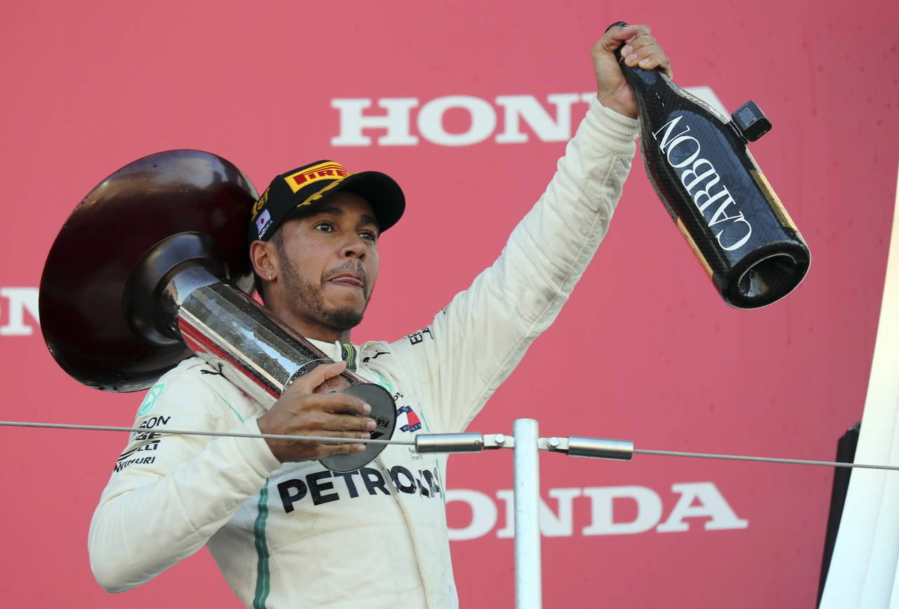 El piloto británico Lewis Hamilton, de Mercedes, festeja en el podio tras ganar el Gran Premio de Japón de la Fórmula Uno.