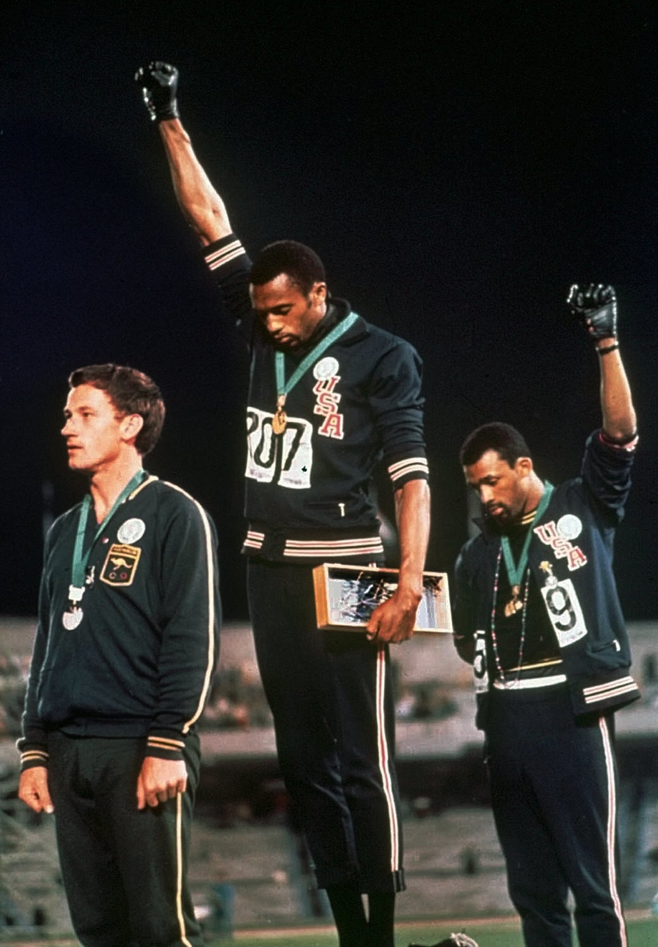 Los atletas estadounidenses Tommie Smith (centro) y John Carlos levantan un puño en el podio de los 200 metros durante los Juegos Olímpicos de México, el 16 de octubre de 1968.