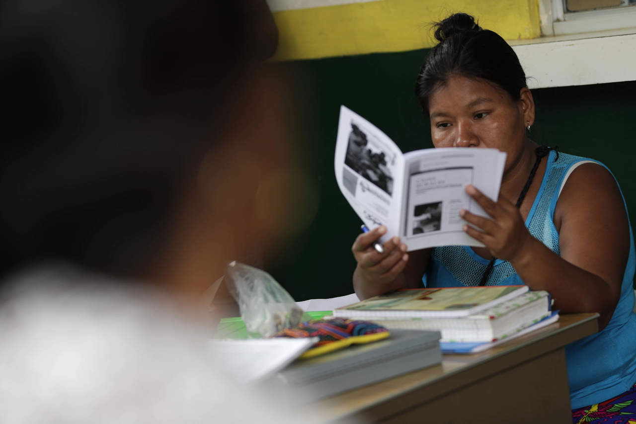 Fotografía del 9 de octubre de 2018, que muestra a una mujer mientras lee un manual de manejo de una caja rural, en la comunidad de Ipetí Emberá-Alto Bayano, en el distrito de Chepo (Panamá). Una propuesta de mujeres para convertir una 'caja rural' en banco  para acabar la marginación que sufren. (ARCHIVO)