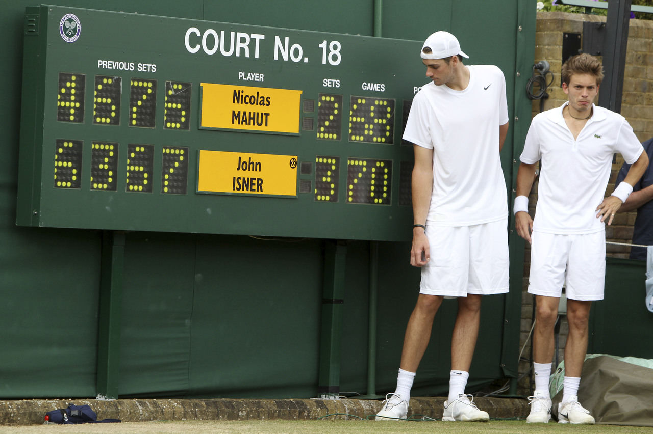 El 24 de junio de 2010, John Isner y Nicolas Mahut (d) posan junto al marcador de su partido que fijó un récord de duración en Wimbledon.
