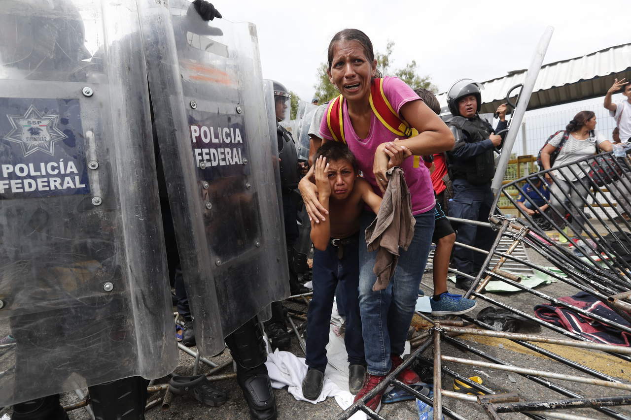 A la fuerza. Migrantes hondureños rompen las rejas y cruzan la frontera de Guatemala con México. La caravana, que se dirige hacia Estados Unidos, cruzó a la fuerza el primer cerco policial de unos cien antimotines e ingresó al país.
