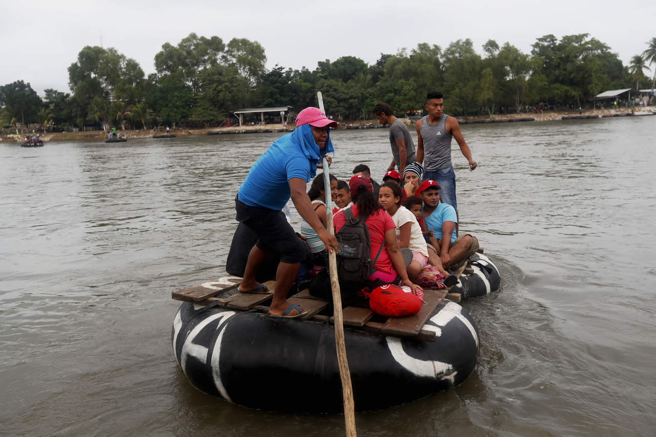 Migrantes hondureños cruzan en balsa el río fronterizo de Guatemala y México. (EFE) 
