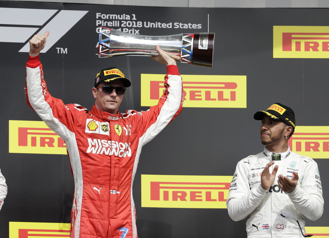 El británico Lewis Hamilton observa al finlandés Kimi Raikkonen levantar el trofeo del Gran Premio de los Estados Unidos, en Austin.