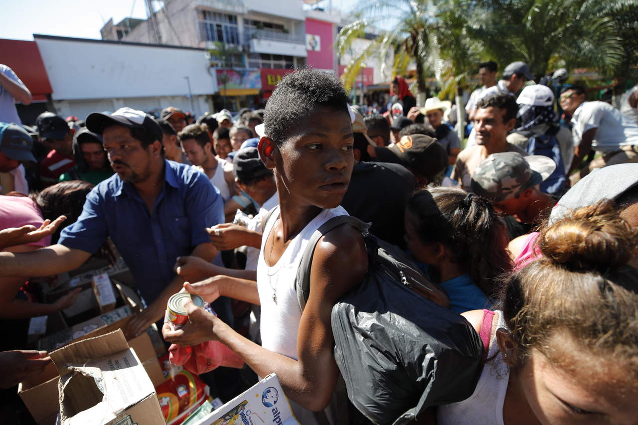 Migrantes hondureños reciben comestibles y se preparan para continuar su camino el lunes 22 de octubre de 2018, en el jardín Hidalgo de Tapachula, en el estado de Chiapas (México). (EFE)