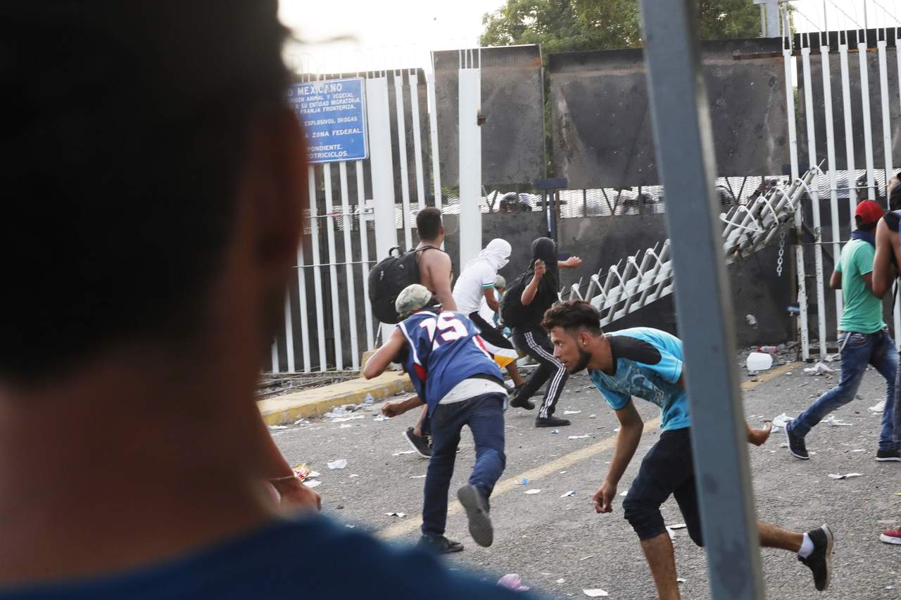 Valla. Migrantes de la segunda caravana se enfrentan con policías. (EFE) 