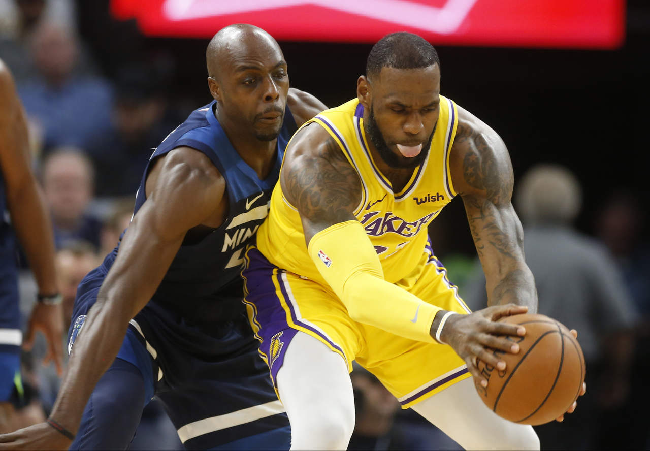 Anthony Tolliver (i) y LeBron James disputan la pelota en el duelo entre Timberwolves y Lakers.