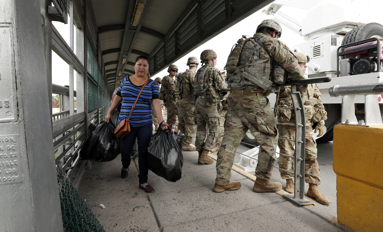 Tensión. Varios usuarios del puente internacional McAllen-Hidalgo cruzaron ante la vigilancia de los militares de EU.