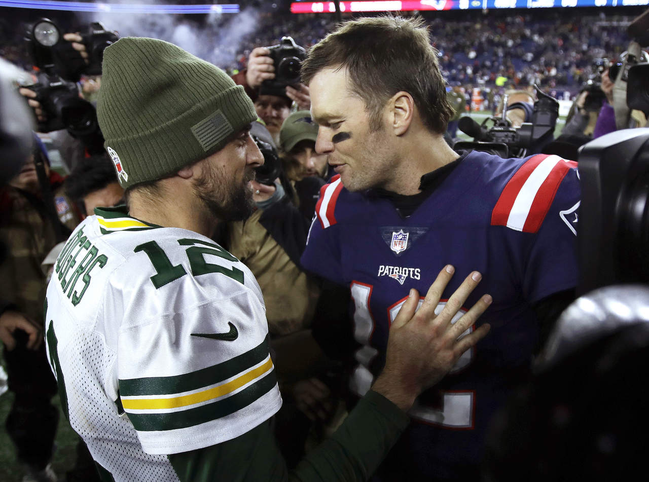 Rodgers (i) reconoce la victoria de su contrincante en turno, Brady, tras el partido entre Patriots y Packers.