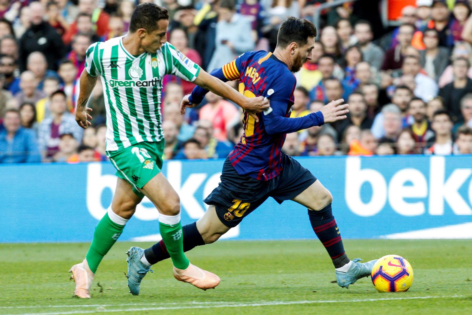 El delantero argentino del FC Barcelona Leo Messi (i), lucha con el centrocampista mexicano del Real Betis Balompié José Andrés Guardado (d), durante el partido de la jornada 12 de liga en Primera División.