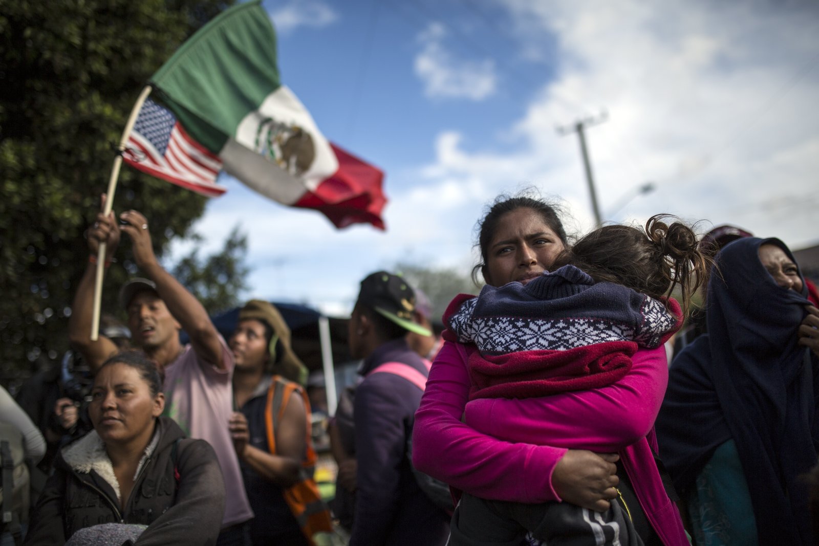 Tensión. La hondureña Leticia Núñez abraza a su hija durante la marcha pacífica que llevaron a cabo el jueves en Tijuana los inmigrantes de la caravana que pretende cruzar a Estados Unidos. (AP)