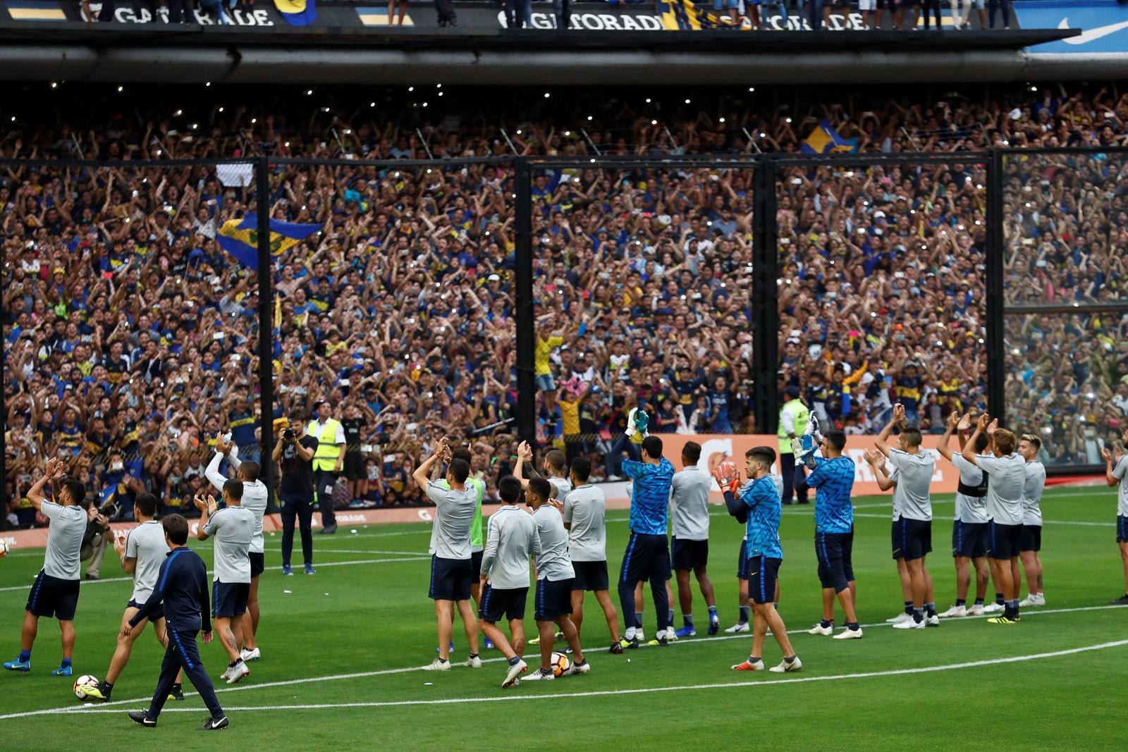 Jugadores de Boca Juniors saludaban a hinchas ayer, durante un entrenamiento de preparación para la final de la Copa Libertadores, en Buenos Aires, Argentina.