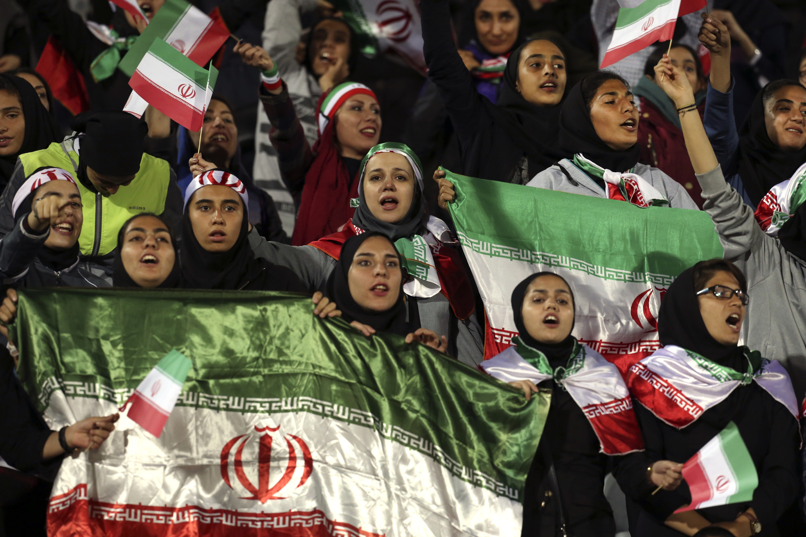 Aficionadas iraníes ondean banderas desde las tribunas durante el partido amistoso entre Irán y Bolivia.