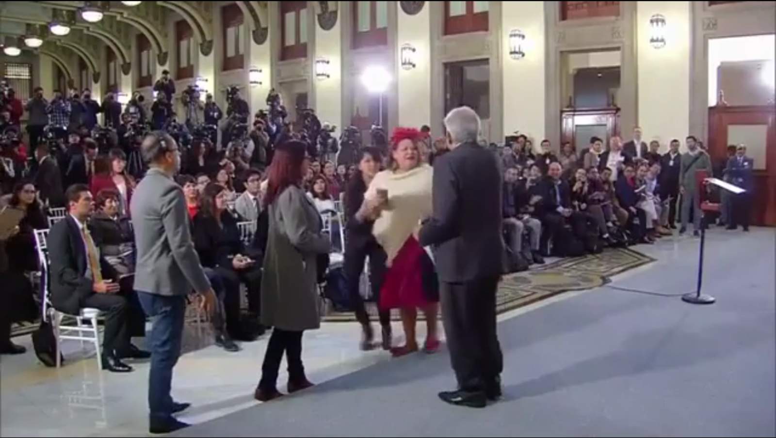 Tras eludir la seguridad de Palacio Nacional una mujer llegó hasta el presidente Andrés Manuel López Obrador al término de la conferencia de prensa mañanera. (ESPECIAL)