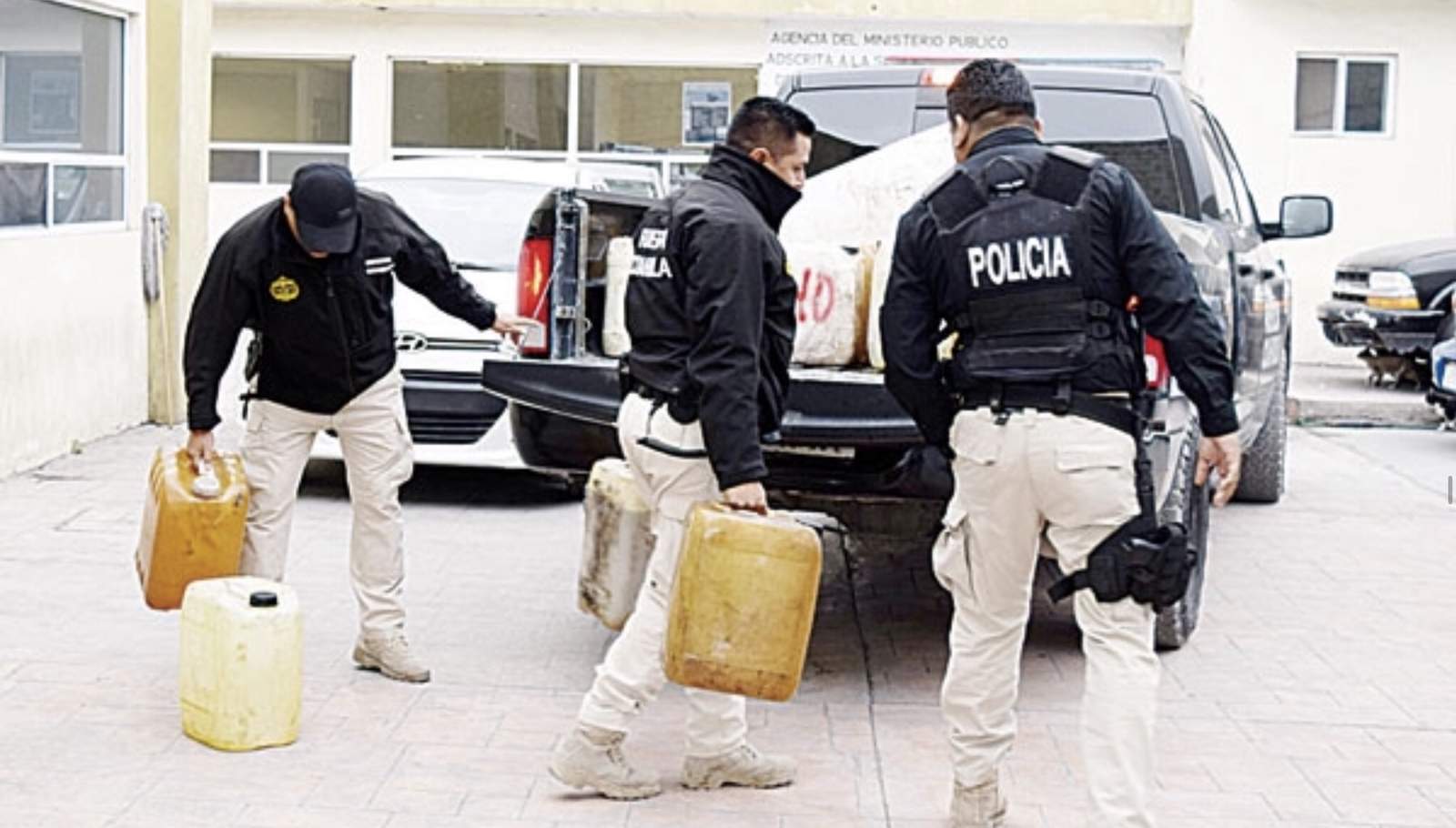 Policías bajando los bidones en los patios de la Fiscalía que fueron encontrados en Castaños. 