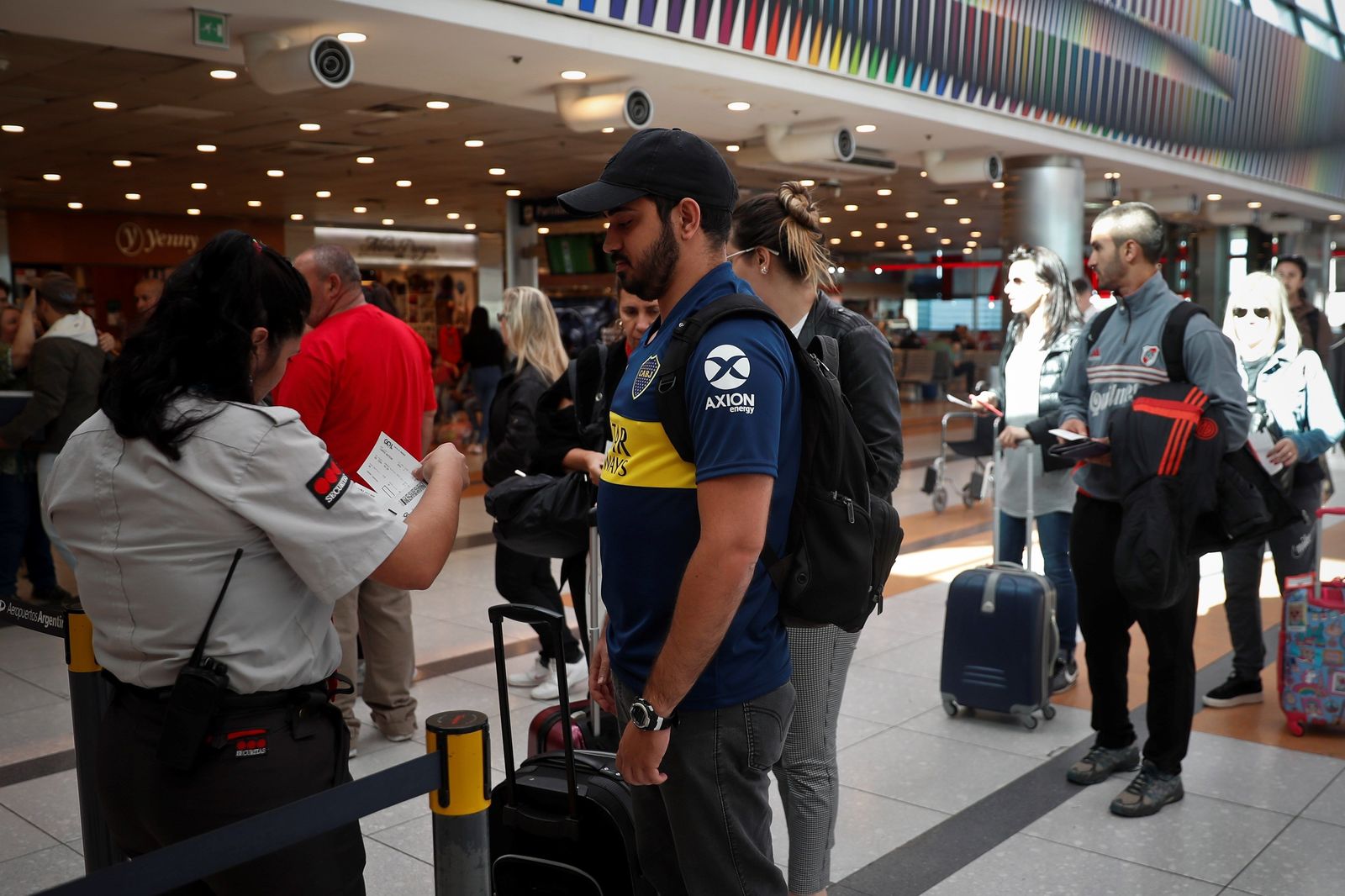 Hinchas del Boca Juniors y River Plate esperan en el Aeropuerto Internacional de Ezeiza para viajar a Madrid.