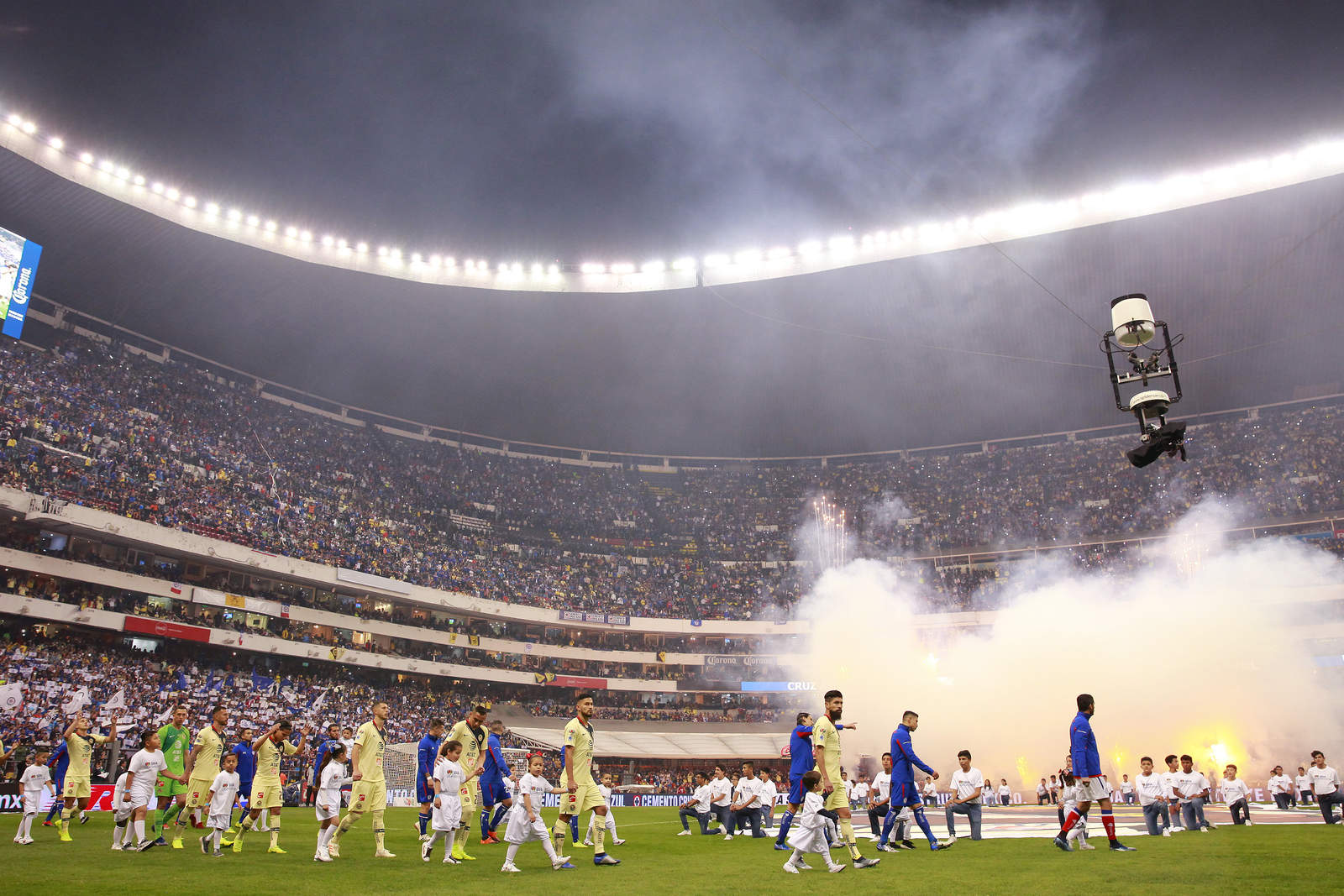 Los jugadores de ambos equipos en su entrada para la gran final del futbol mexicano. (Jam Media)