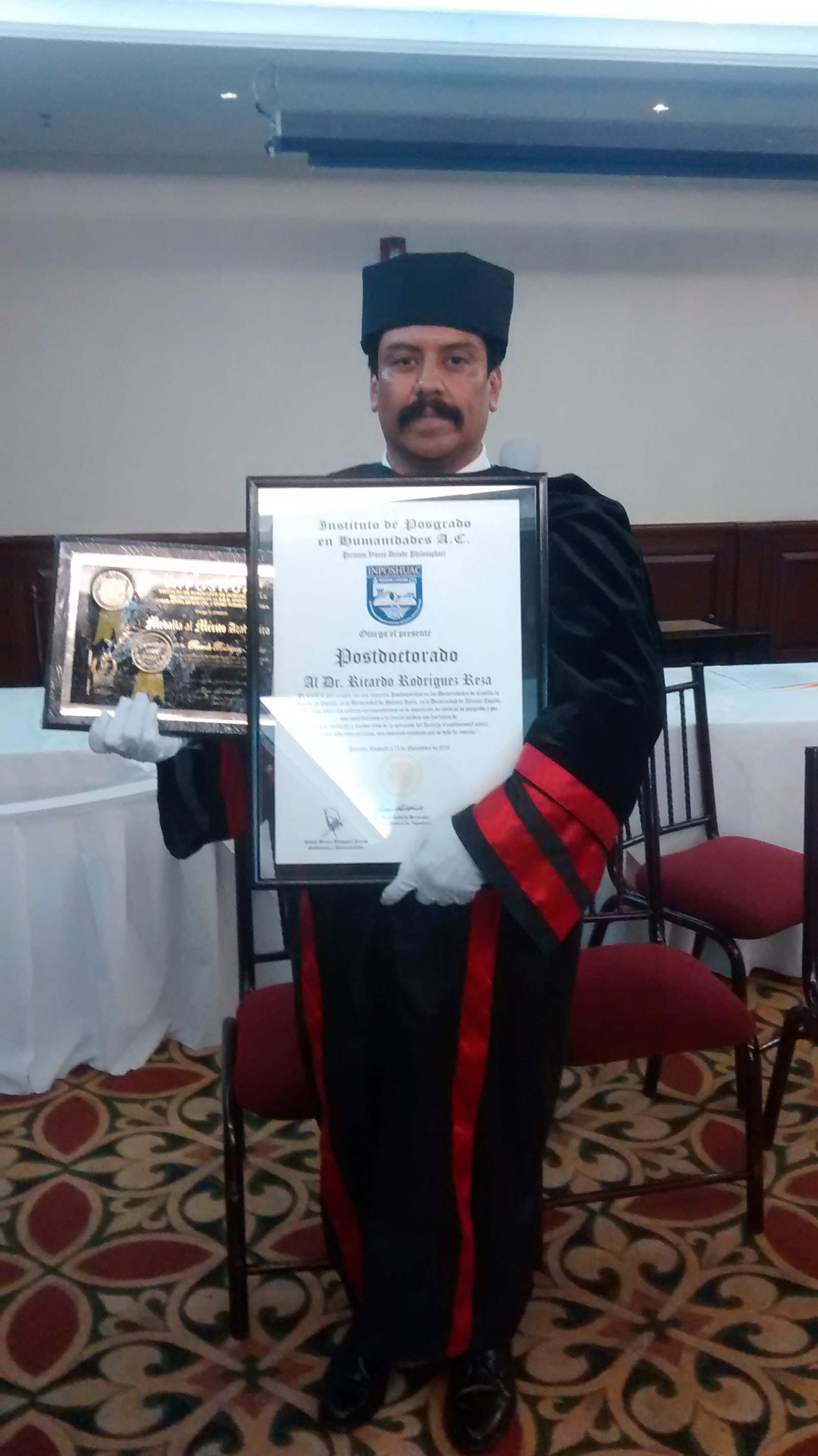 El Dr. Ricardo Rodríguez Reza, sosteniendo orgulloso su titulo en Postdoctorado y su Medalla al Mérito Académico.