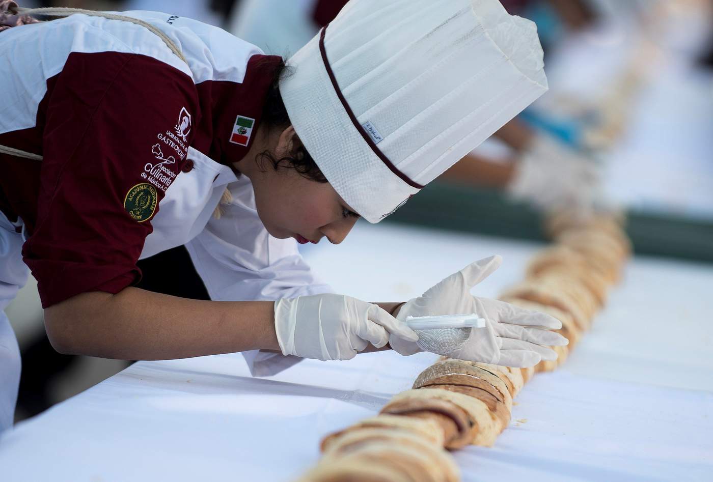Voluntarios participaron en la elaboración de la rosca. (EFE) 