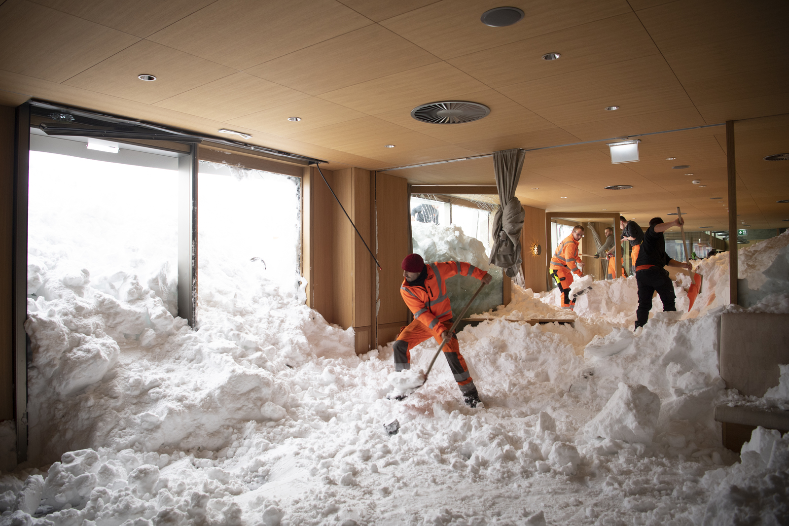 Complica. Personas retiran la nieve que se metió por una avalancha en el hotel Saentis en Suiza.