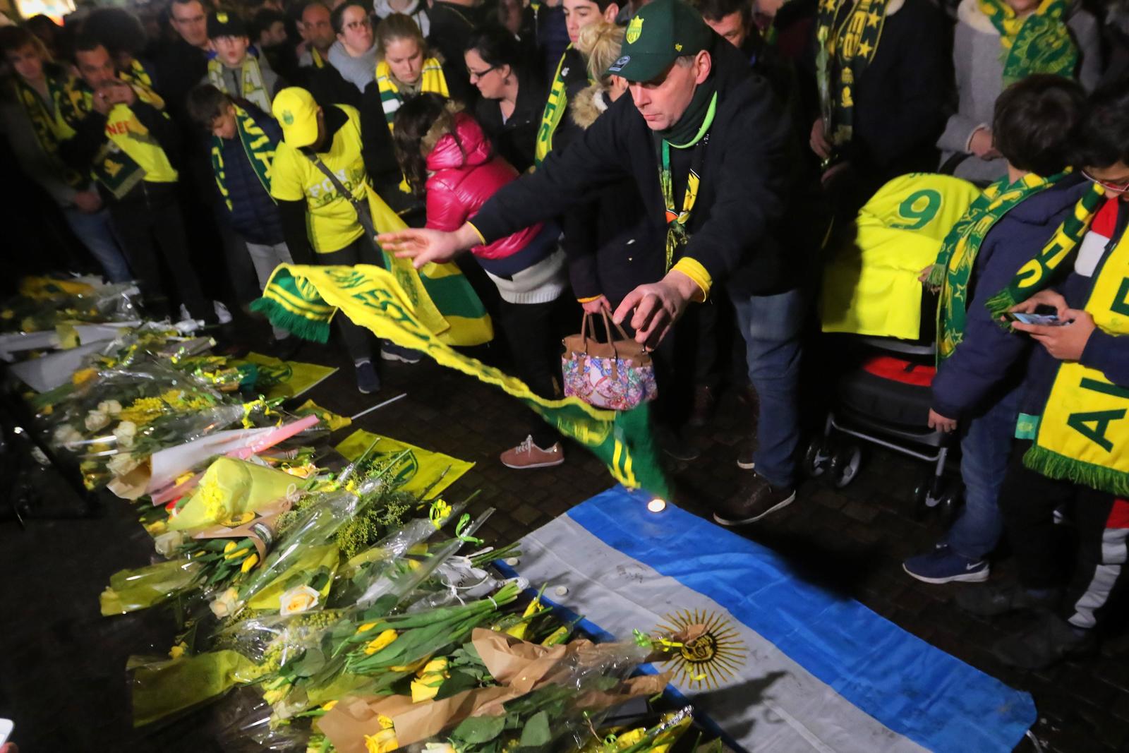 Varias personas realizan una ofrenda floral durante una congregación para conmemorar al jugador argentino de futbol Emiliano Sala, ayer en Nantes, Francia. Aún esperan que se encuentre con vida.