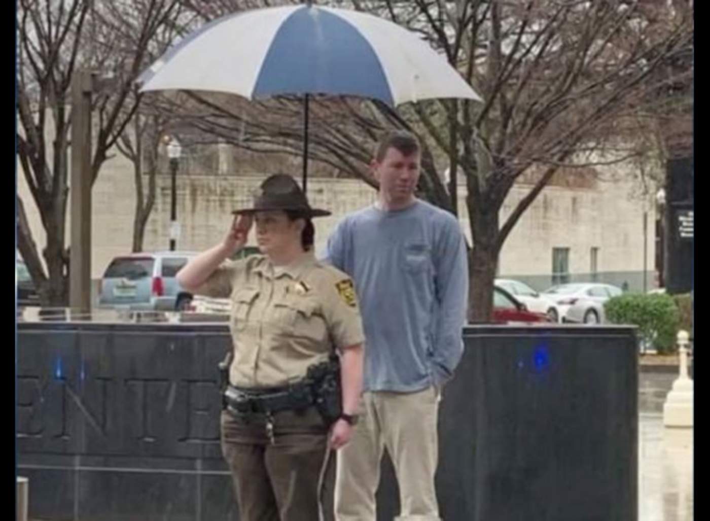Imagen de persona protegiendo de la lluvia a oficial se hace viral