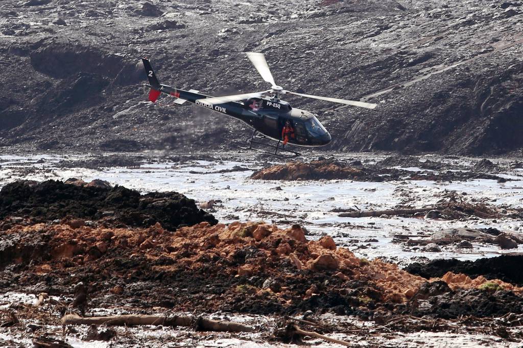 Búsqueda. Un helicóptero busca supervivientes tras el desastre causado por la rotura de una represa. Hay 150 desaparecidos.