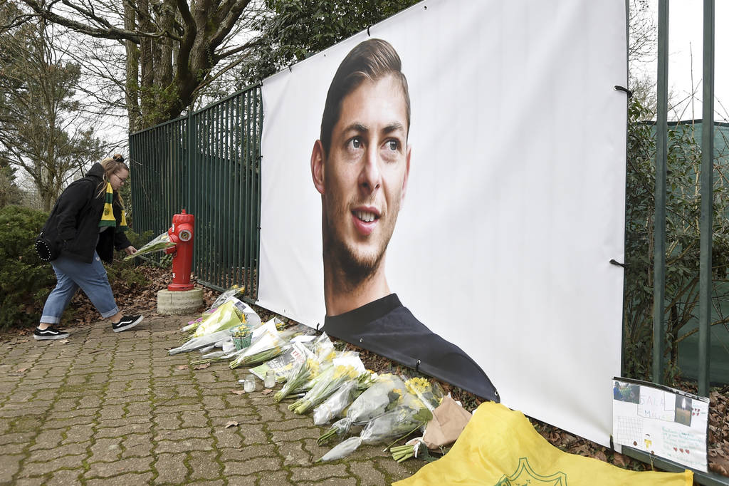 Ramos de flores y otros tributos desplegados cerca de una foto del futbolista argentino Emiliano Sala afuera del predio de entrenamientos del club francés Nantes. (AP) 