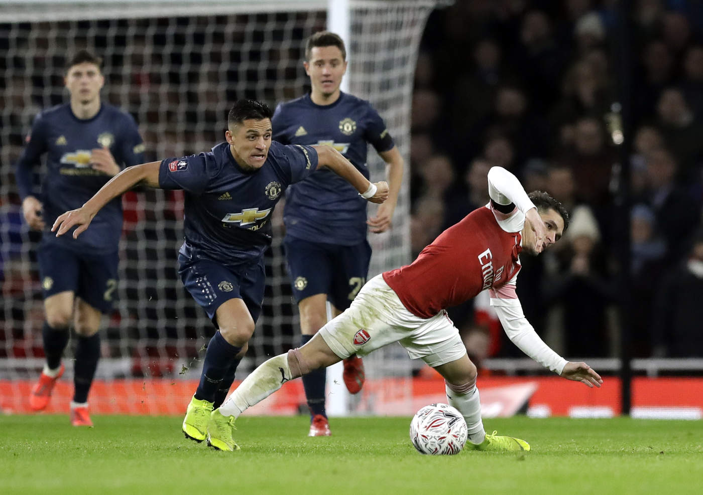 El delantero chileno Alexis Sánchez (izquierda), del Manchester United, pugna por un balón con Lucas Torreira, de Arsenal, en el partido por la cuarta ronda de la Copa FA en Londres. (AP)