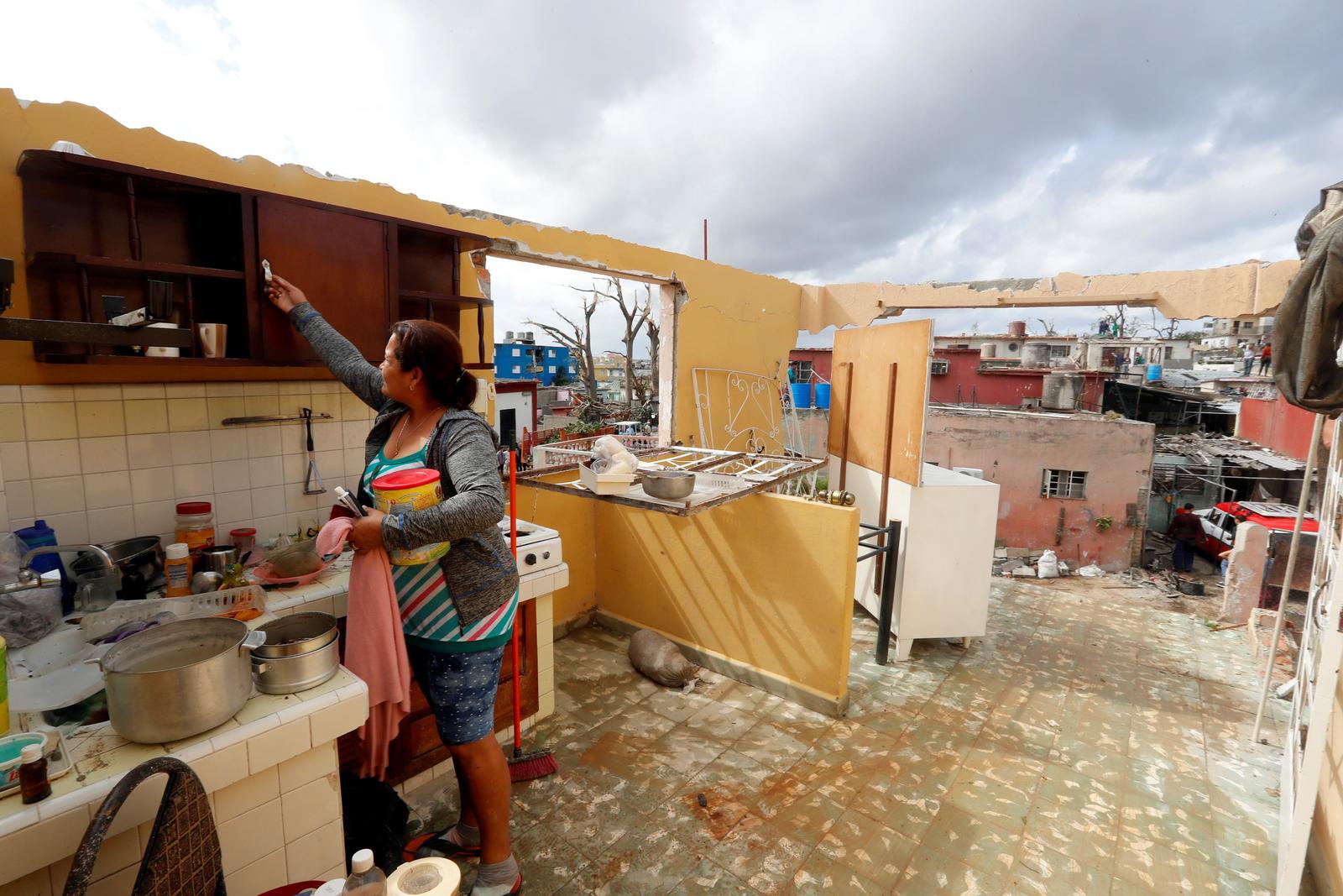 Afectados. Una mujer observa un cuarto de su casa que quedó sin techo, en el municipio de Regla.  (EFE)