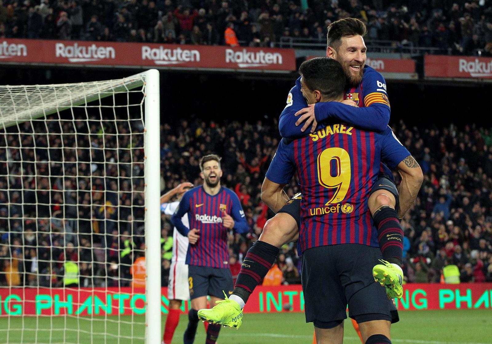 Lionel Messi celebra con Luis Suárez luego de marcar el último gol 'de fantasía' del Barcelona en la paliza sobre Sevilla.