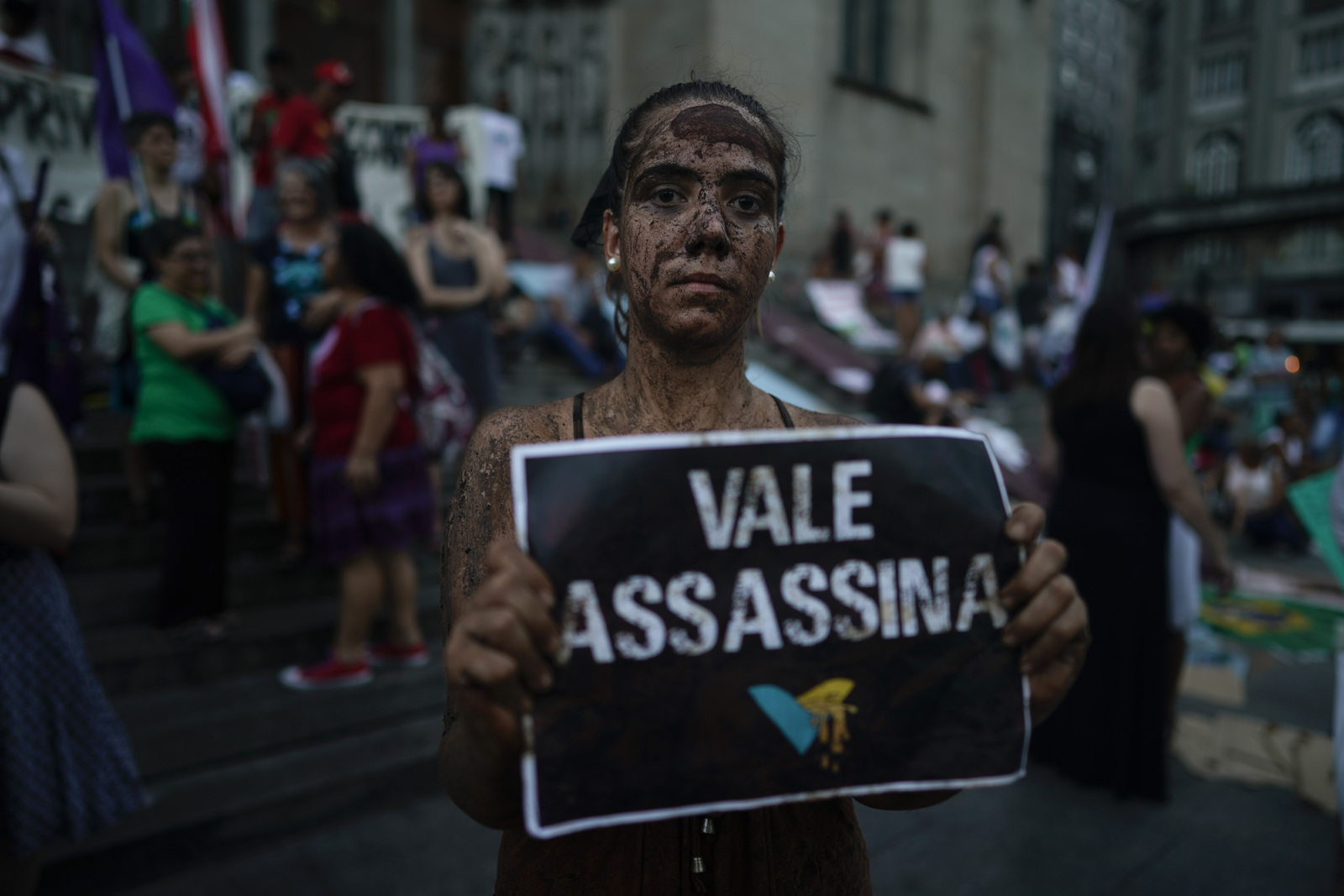 Denuncian. Una activista cubierta de lodo posa con un letrero que dice 'Vale asesina', refiriéndose a la empresa minera Vale.